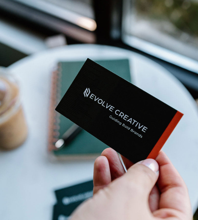 Person holding Evolve Creative business card.