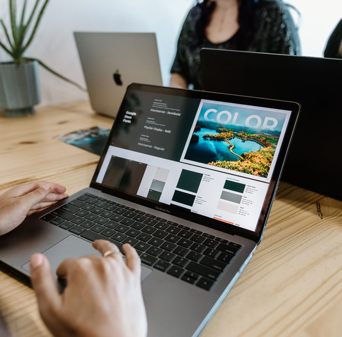Person using laptop for color graphic design work.