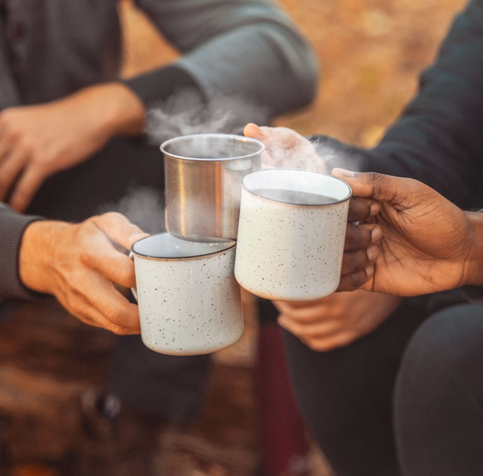 Friends toasting with hot drinks outdoors